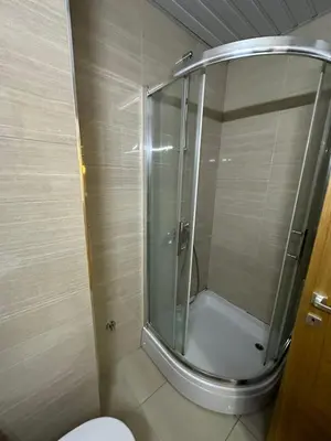 a shower with a glass door in a bathroom at Emina apartment City kvart in Kruševac