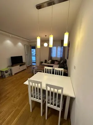 a kitchen and living room with a white table and chairs at Emina apartment City kvart in Kruševac