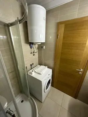 a small bathroom with a washing machine and a toilet at Emina apartment City kvart in Kruševac