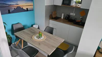 a kitchen with a wooden table and chairs at Studio-apartman Aroma in Bar