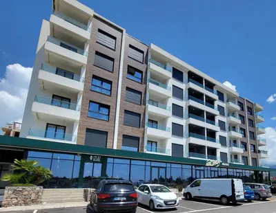 a large building with cars parked in a parking lot at Studio-apartman Aroma in Bar