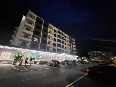 a building with cars parked in a parking lot at night at Studio-apartman Aroma in Bar