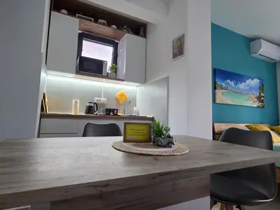 a kitchen and dining room with a table and chairs at Studio-apartman Aroma in Bar