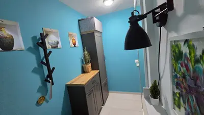 a room with a blue wall and a black lamp at Studio-apartman Aroma in Bar