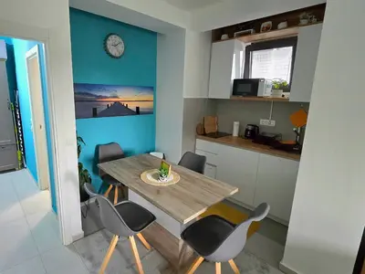 a kitchen with a dining room table and chairs at Studio-apartman Aroma in Bar