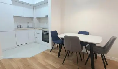 a kitchen and dining room with a table and chairs at Sabina apartment City kvart in Podgorica