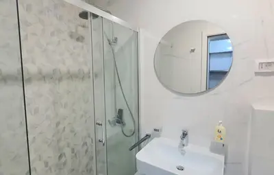 a bathroom with a shower and a sink and a mirror at Sabina apartment City kvart in Podgorica