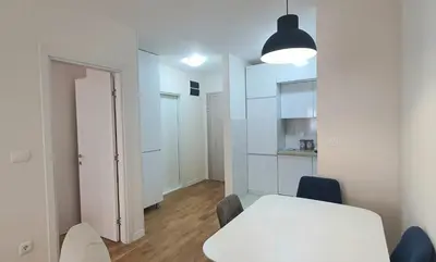 a white room with a white table and a white cabinet at Sabina apartment City kvart in Podgorica