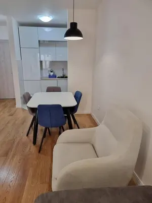 a living room with a couch and a table and chairs at Sabina apartment City kvart in Podgorica
