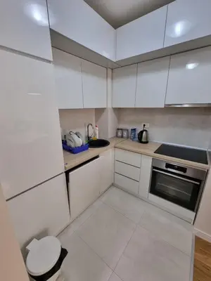 a small kitchen with white cabinets and a sink at Sabina apartment City kvart in Podgorica