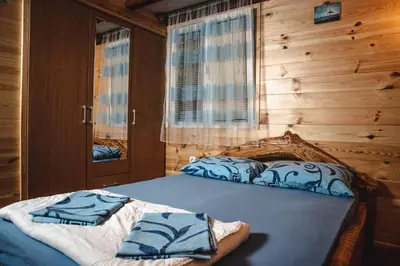 a bedroom with a bed with blue sheets and a window at Bamboo River House in Ulcinj