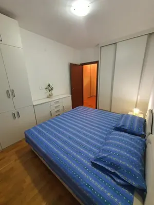 a bedroom with a bed with a blue comforter at Ana apartment City kvart in Podgorica