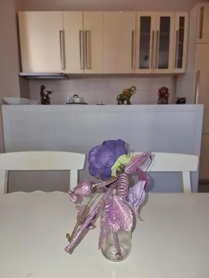 a vase filled with purple flowers sitting on a table at Ana apartment City kvart in Podgorica