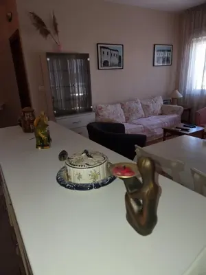 a living room with a table with a cake on a counter at Ana apartment City kvart in Podgorica