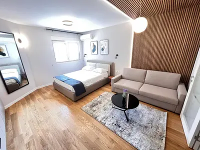 a bedroom with a bed and a couch and a table at APART 28- Luxury suites in Podgorica