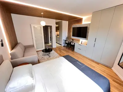 a bedroom with a white bed and a living room at APART 28- Luxury suites in Podgorica