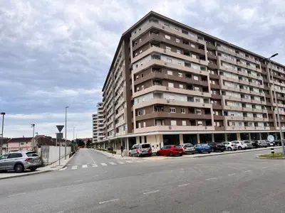 a large building with cars parked in a parking lot at APART 28- Luxury suites in Podgorica