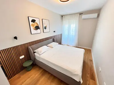 a small bedroom with a bed with white sheets at APART 28- Luxury suites in Podgorica