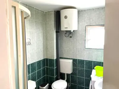 a green bathroom with a toilet and a sink at Villa Happy Family in Seoca