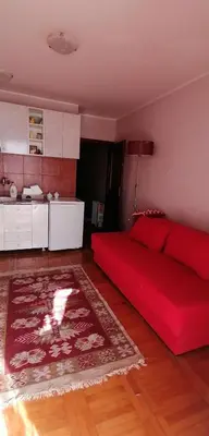 a living room with a red bed and a kitchen at Marko Apartmani in Budva