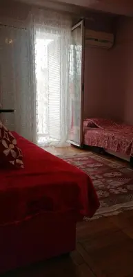 a bedroom with a red bed and a window at Marko Apartmani in Budva