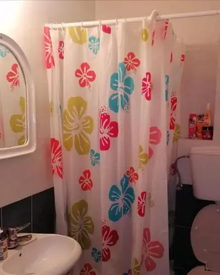 a bathroom with a shower curtain with flowers on it at Marko Apartmani in Budva