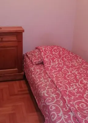 a bed with a red comforter in a room at Marko Apartmani in Budva