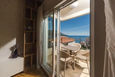 a room with a balcony with a table and chairs at Nest 1 in Becici