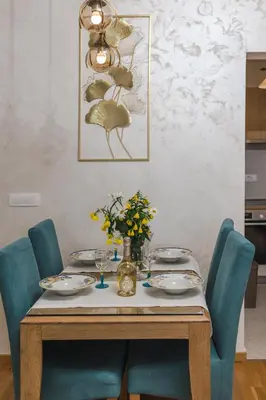 a dining room table with blue chairs and a table with flowers at Nest 1 in Becici