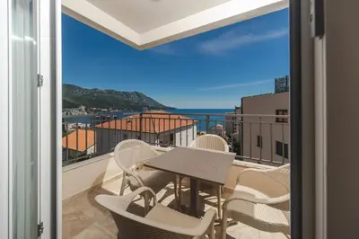 a balcony with a table and chairs and a view of the ocean at Nest 1 in Becici