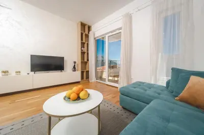 a living room with a blue couch and a table at Nest 1 in Becici
