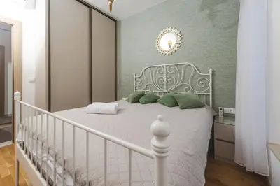 a bedroom with a white bed with green pillows at Nest 1 in Becici