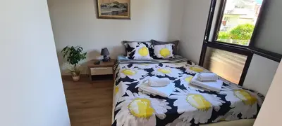 a bedroom with a bed with a black and yellow comforter at Orlic Apartman in Budva