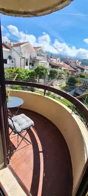 a balcony with a table and a chair on a patio at Orlic Apartman in Budva