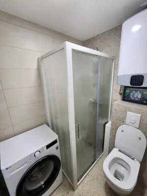 a bathroom with a toilet and a glass shower at Orlic Apartman in Budva