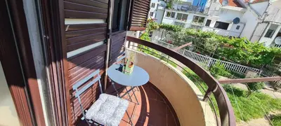 a small table on a balcony with a railing at Orlic Apartman in Budva