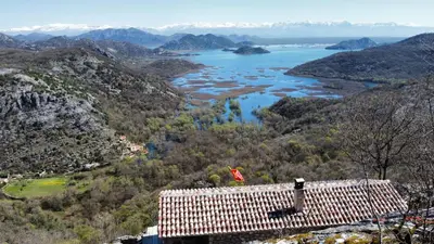 a view of a valley with a river and mountains at Panorama Stone Houses - Skadar Lake in Cetinje