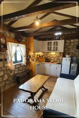 a kitchen with a table and a stone house at Panorama Stone Houses - Skadar Lake in Cetinje