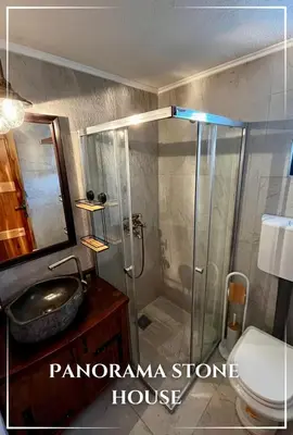 a bathroom with a shower with a sink and a toilet at Panorama Stone Houses - Skadar Lake in Cetinje