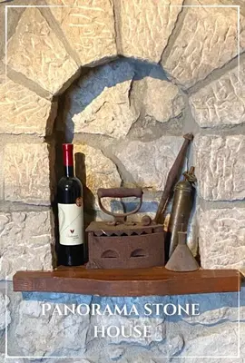 a bottle of wine sitting on a stone wall at Panorama Stone Houses - Skadar Lake in Cetinje