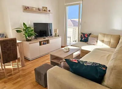 a living room with a couch and a tv at Blanc 1664 in Podgorica