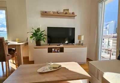 a living room with a flat screen tv and a table at Blanc 1664 in Podgorica