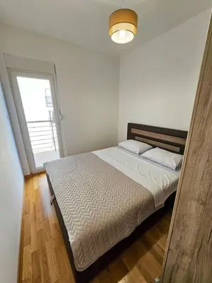 a bedroom with a large bed with a window at Blanc 1664 in Podgorica
