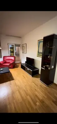 a living room with a red couch and a table at Aida apartment City kvart in Podgorica