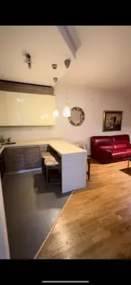 a living room with a table and a red couch at Aida apartment City kvart in Podgorica