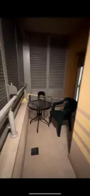a balcony with a table and a chair in a room at Aida apartment City kvart in Podgorica
