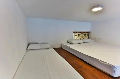 two beds in a room with white walls and wooden floors at SS Studio Oaza mira in Bar, Susanj