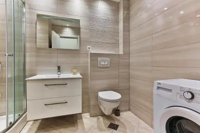a bathroom with a toilet and a sink and a washing machine at SS Studio Oaza mira in Bar, Susanj