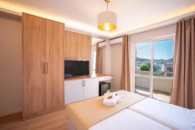 a bedroom with a bed and a large window at Illyria Hotel in Ulcinj