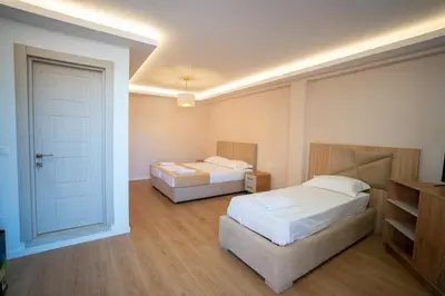a hotel room with two beds and a door at Illyria Hotel in Ulcinj
